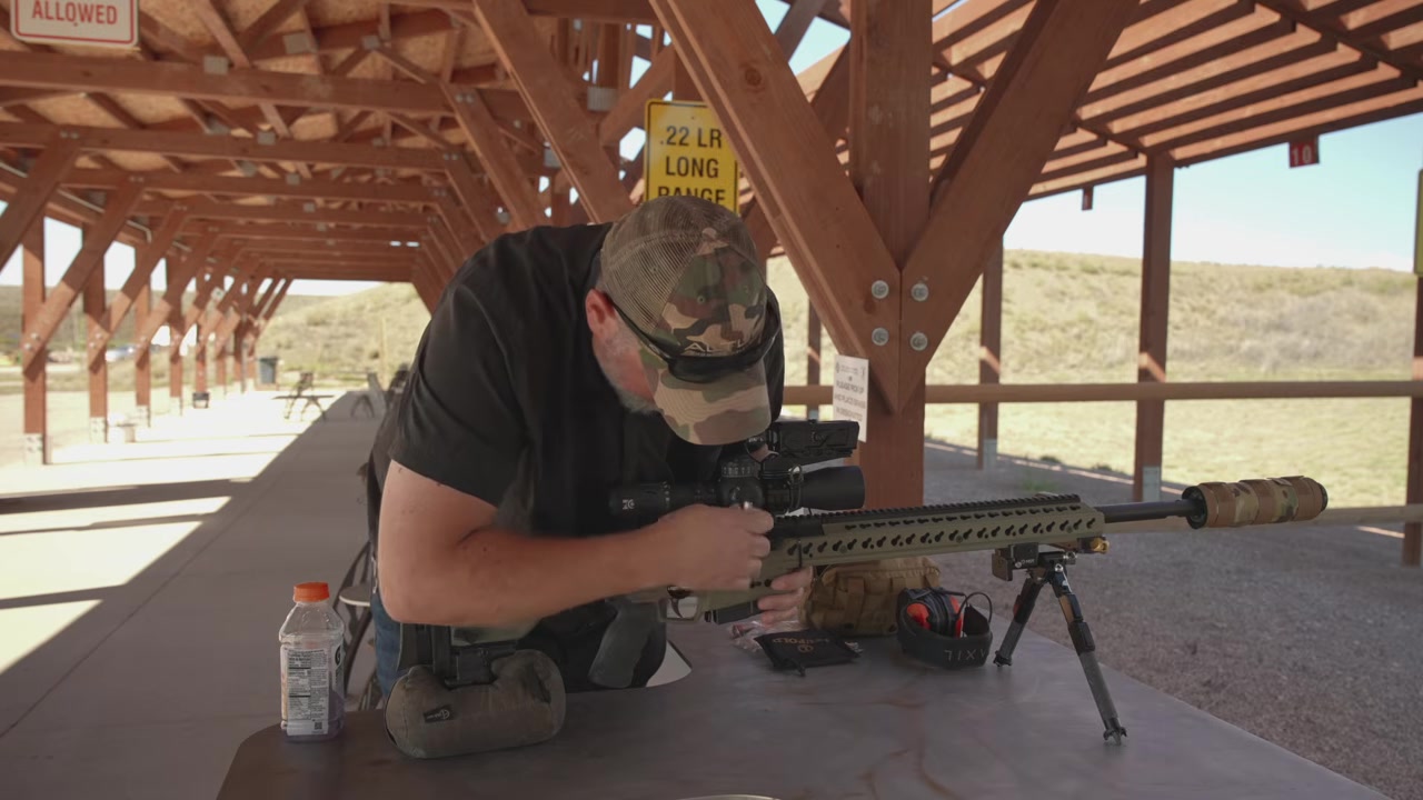 Joel leaning over the rifle and checking the torque on the scope mount and ring screws at the bench