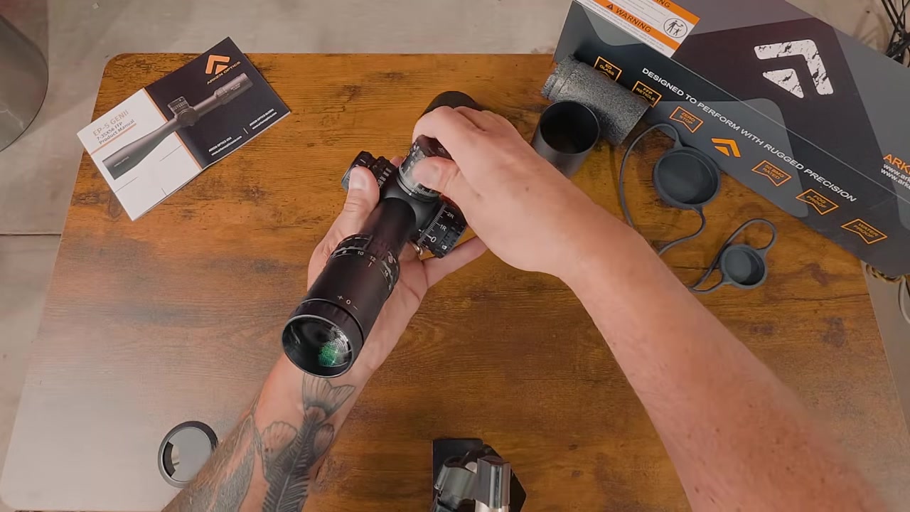 Hands turning the controls of the Arken EP5 Gen 2 scope to test turret feel