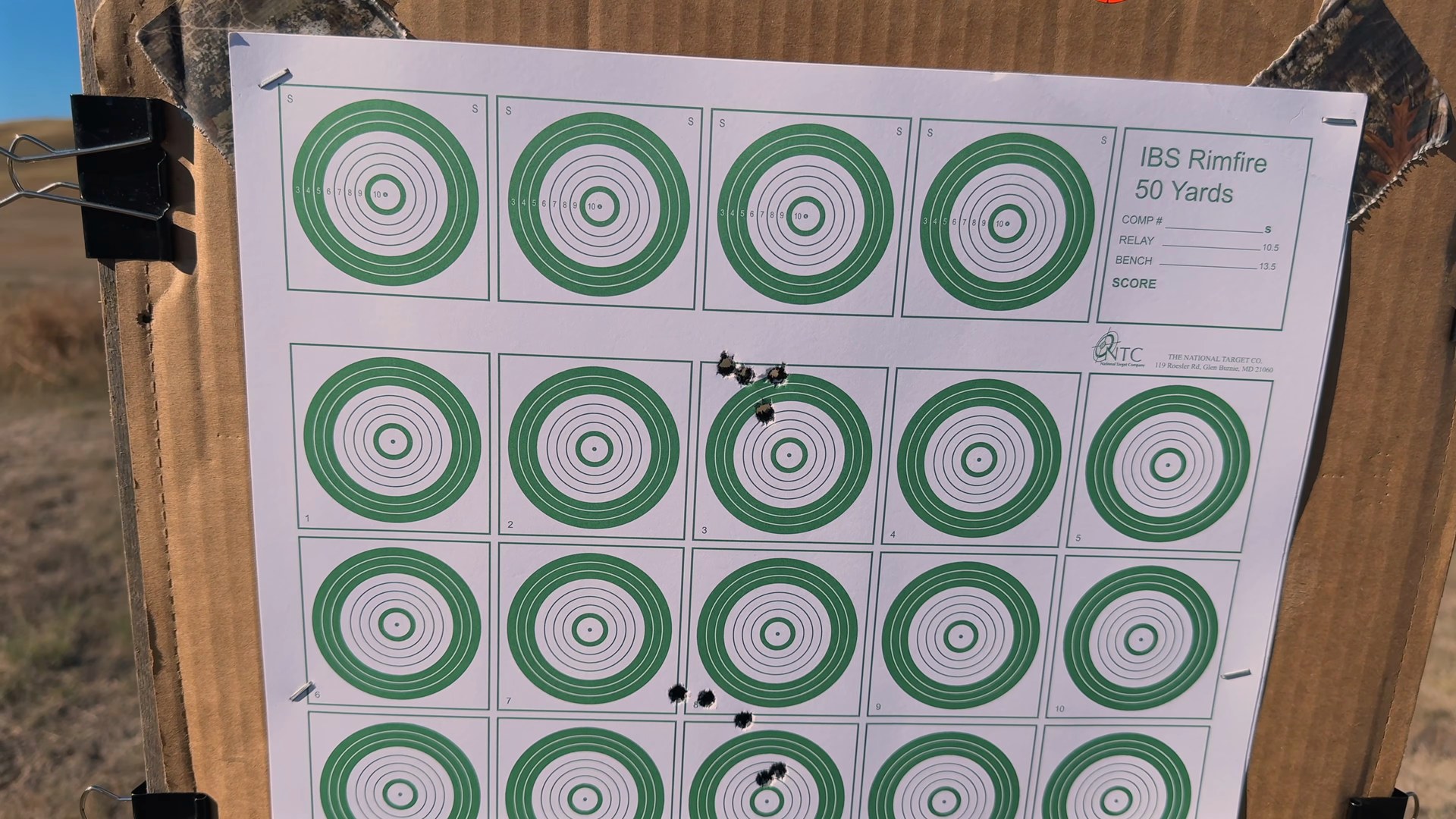 100 yard target showing the tight Berger 6.5 PRC ammo group up top and the scattered Hornady group below